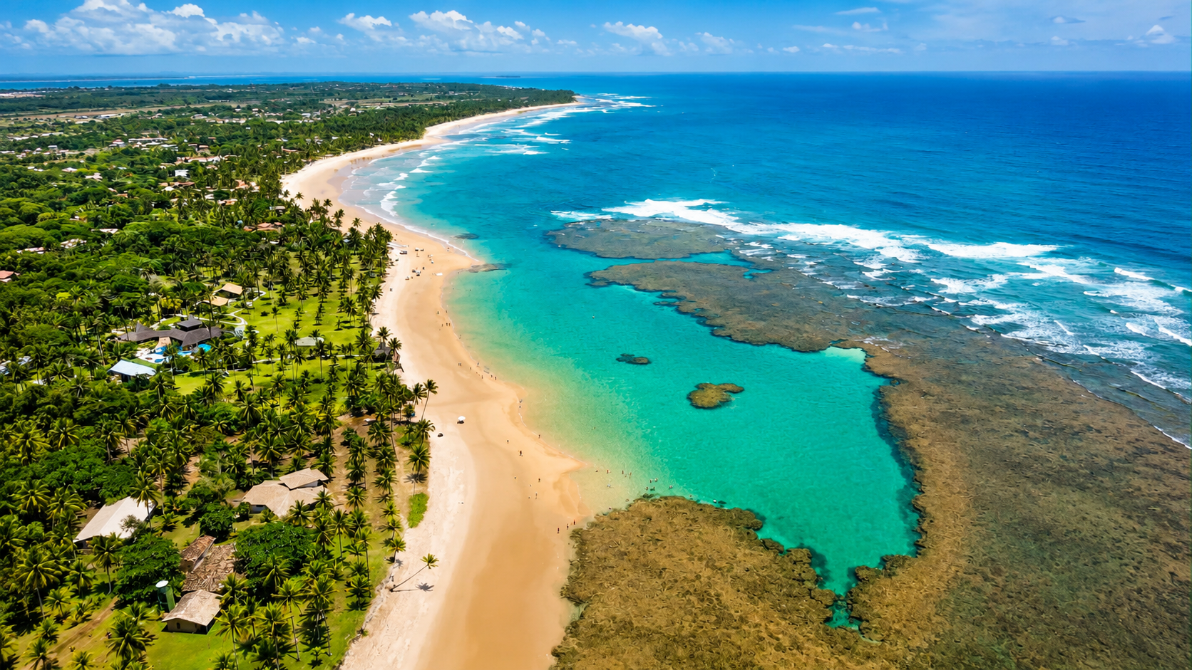 Vista aérea da orla de Maraú com coqueiral, areia e mar azul