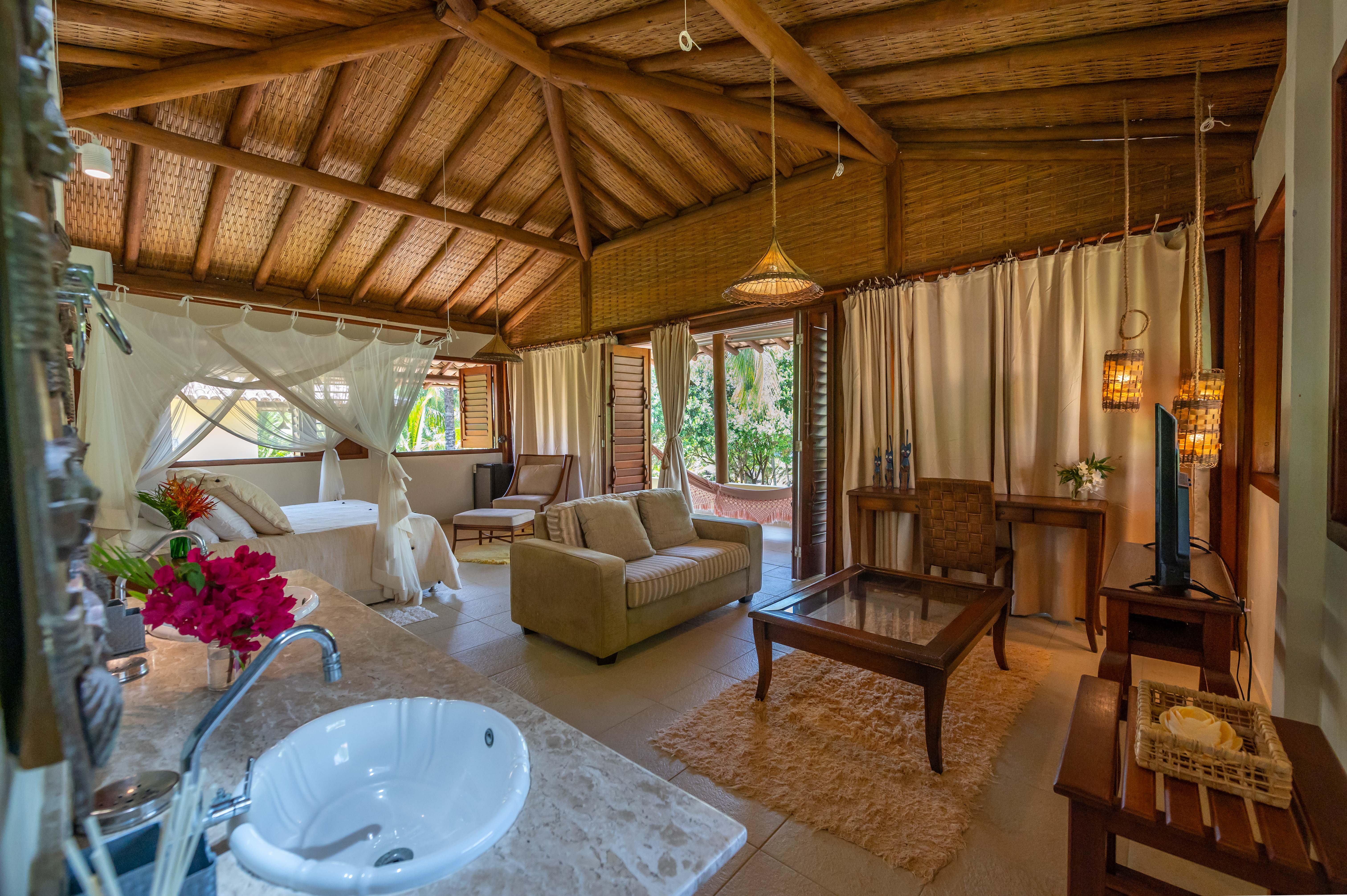 Suíte master com sala de estar, sofá e banheira